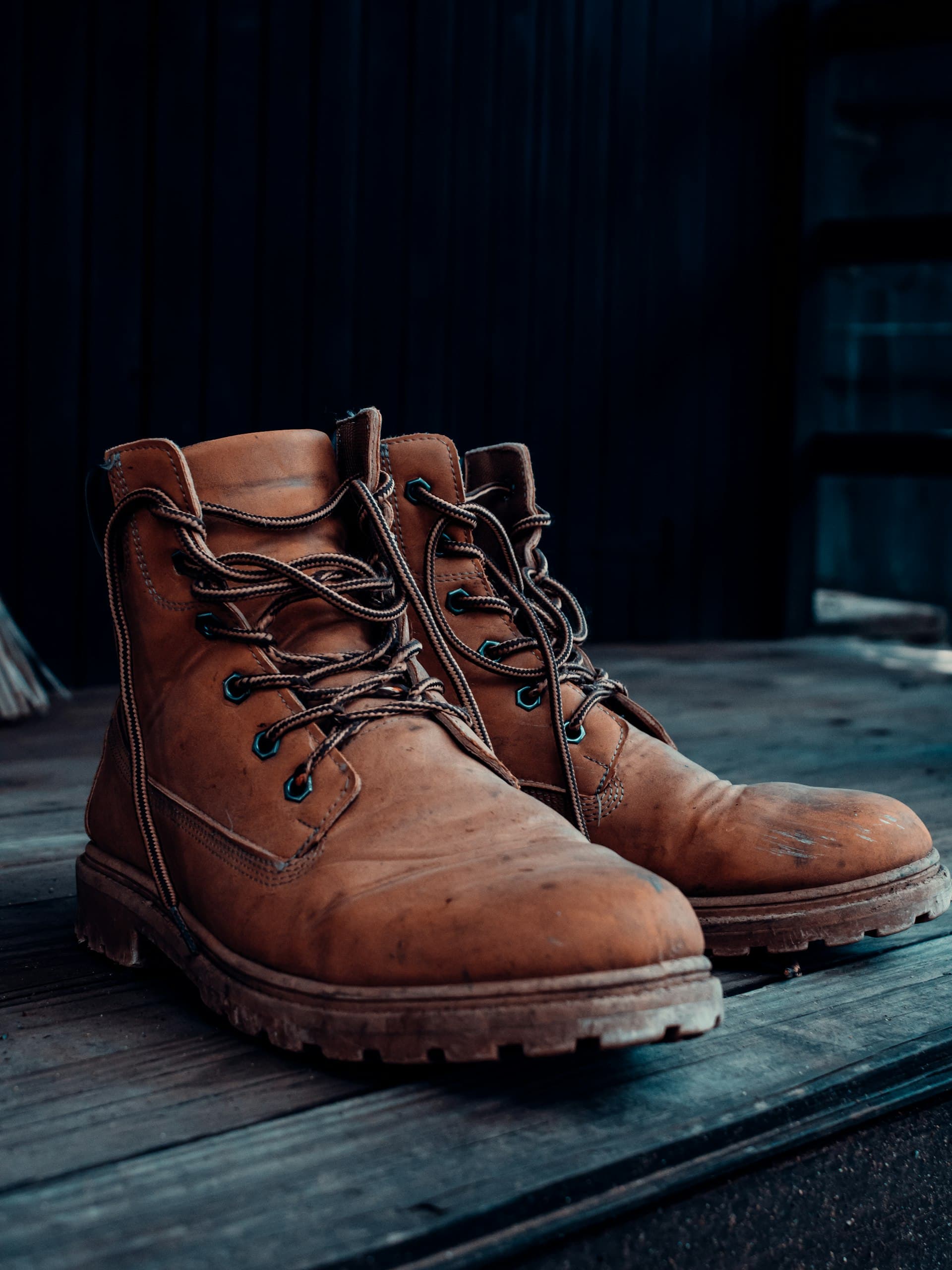 Handcrafted pure leather boots resting on a wooden floor